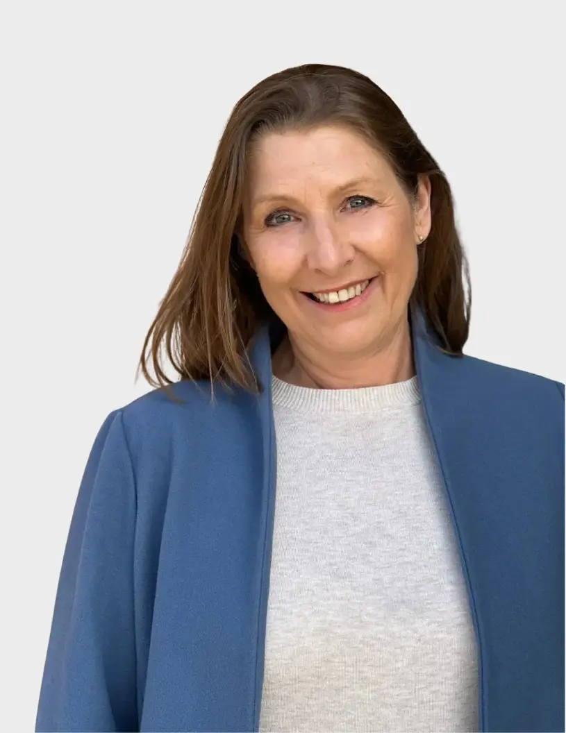 Kvinna glad, med glimten i ögat med blå jacka och grå tröja - Anette Jernström