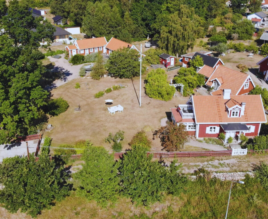 Röda hus med vita knutar som ligger i grupp med rött staket runt om